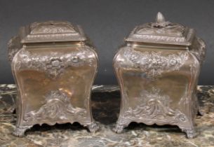 A pair of George II silver bombe shaped tea caddies, domed covers, each chased with flowers and