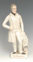 A Staffordshire figure of Wellington, standing by a draped pedestal, gilt titled rectangular base,