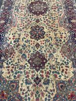 A large Persian Kerman woollen rug or carpet, stylised flowers and geometric motifs, in tones of