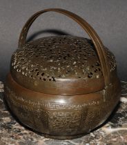 A Chinese brass melon shaped hand warmer or brazier, pierced, chased and engraved, swing handles,