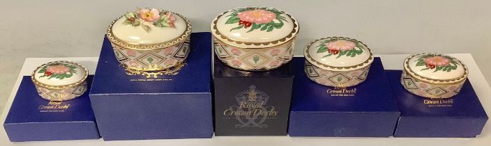 A set of five Royal Crown Derby Wild Rose pattern graduated oval trinket dishes and covers, the