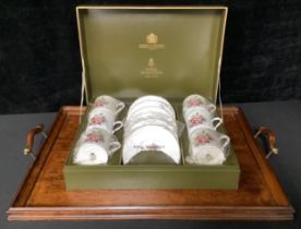 A Royal Worcester coffee set for six, printed with a spray of summer flowers, boxed; a mahogany