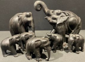 A set of seven carved ebonised Elephant family models, the largest 27cm high