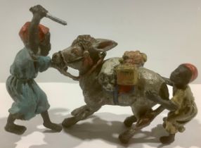 An Austrian cold painted bronze figure group, donkey with paniers and pair of "encouraging"