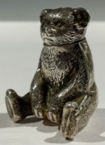 An Edwardian silver novelty pepper, in the form of a seated teddy bear, 3.5cm high, Birmingham 1909,