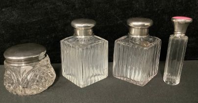 A pair of early George V clear glass facetted square scent bottles, domed silver covers, clear glass