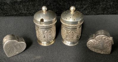 Two silver heart shaped pill boxes or bonbonnieres; a pair of Malaysian silver condiments (4)