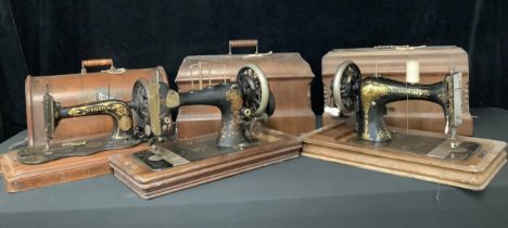 An early 20th century Frister & Rossman hand cranked sewing machine, cased; others, Singer, etc (3)