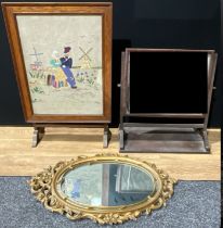 An oak metamorphic combination fire screen and table, the top set with needlework panel, of a