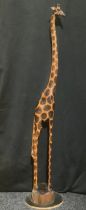 An African carved and poker work wooden giraffe model, stylised long slender neck and legs, floor