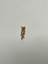 A 9ct gold owl brooch, perched on a branch, the feathers bright cut and engraved, set with a pair of