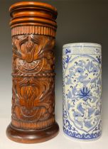 A reproduction cylindrical walking stick and umbrella stand, carved with leafy scrolls, stop