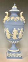 A Wedgwood Jasperware two-handled pedestal urn and cover, the handles with Bacchic mask terminals,