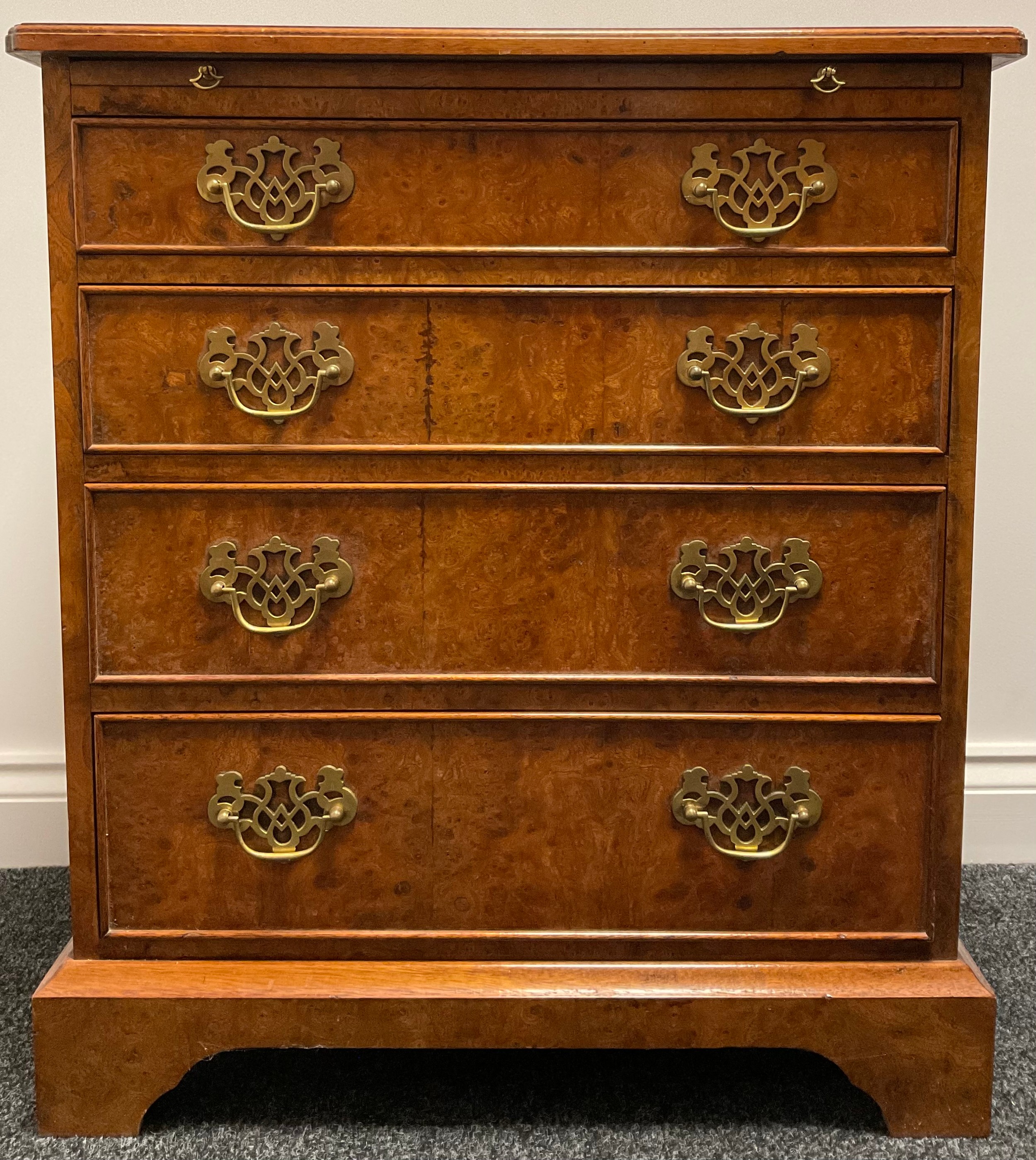 A George I style amboyna bachelors chest, quarter veneered top outline with boxwood stringing, the