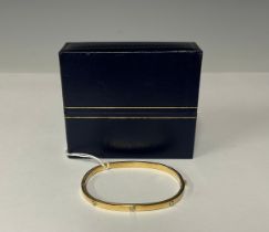 A 9ct gold hinged bangle, cast with six rivets, 6cm interior, marked 375, 6.5g, boxed