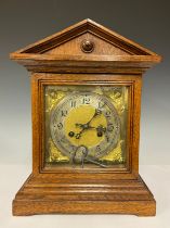 An Edwardian Oak mantle clock, square brass dial, silvered chapter ring, Arabic numerals, striking
