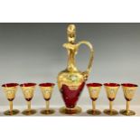 A Murano ruby glass decanter and six wine glasses, gilded and painted with flowers in relief; a