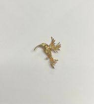 A 9ct gold Hummingbird brooch, as a bird in flight, the feathers bright cut and engraved, single