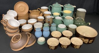 A Denby Cotswold pattern tea pot, ten cups and saucers, three graduated cream or milk jugs, pair