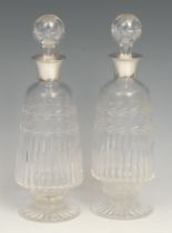 A pair of George V silver mounted cut glass ovoid pedestal liqueur decanters, 25cm high, William