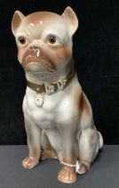 A large early 20th century Staffordshire fireside model, of a seated pug dog, 34cm