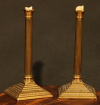 A pair of George III brass fluted square candlesticks, of seamed construction, stepped square