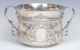 A large Victorian Irish silver porringer, half-fluted chased and punched, and centred by an oval