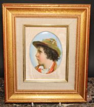 A 19th century German porcelain oval plaque, probably Berlin, portrait of a young boy wearing a hat,