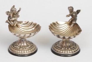 A pair of early 20th century Continental silver coloured metal salts, each as a shell surmounted