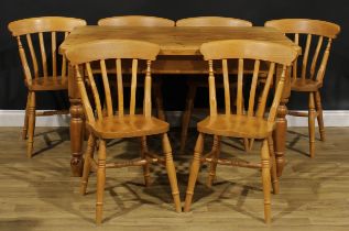 A farmhouse pine dining table, 77cm high, 137cm long, 91cm wide; a set of six lath back side chairs,