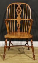 A yew, beech and elm wheelback Windsor elbow chair, saddle seat, turned legs, crinoline stretcher,