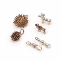 A collection of unmarked white metal charms, comprising two hedgehogs and two dogs (4)