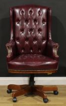A contemporary swivel desk chair, Chesterfield type upholstery, 119.5cm high, 67cm wide, the seat