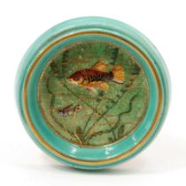 An early 20th century Art Pottery circular wall plaque, of small proportions, decorated with fish