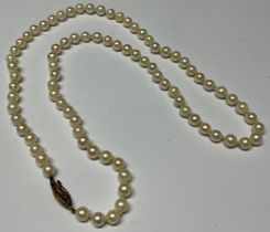 A single strand of uniform cultured pearls, 30cm drop, the 9ct rose gold clasp set with three seed