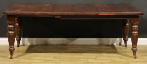 A late Victorian/Edwardian walnut extending dining table, canted rectangular top with two additional