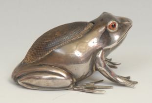 An Edwardian silver novelty pin cushion, as a frog, glass eyes, 6cm long, Saunders & Shepherd,