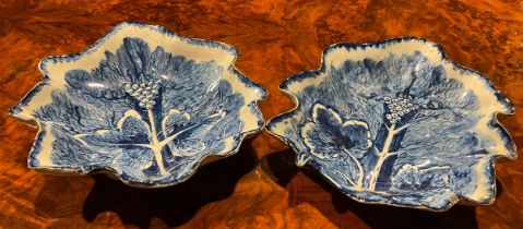 A near pair of large Bow leaf shaped dishes, painted in dark blue with grape and vine, the largest