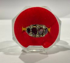 A 19th century 9ct gold ring set with an arrangement of garnet and seed pearls, size O, marked