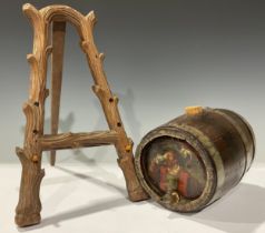 A Black Forest display easel; a 19th century spirit barrel painted with man quaffing ale