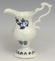 A Liverpool pedestal cream jug, moulded with flowers, decorated in underglaze blue with floral