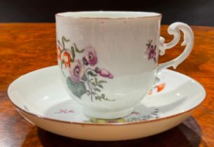 A Meissen coffee cup and saucer, painted with floral bouquets and scattered flowers, brown line