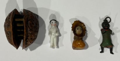 A Victorian miniature doll in walnut shell; a miniature cast and cold painted Robinson’s style doll;