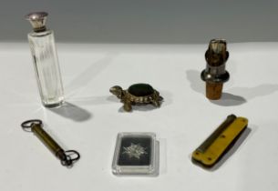 An enamel and silver topped scent bottle; a tortoise pin cushion; miniature scales; a pipe smokers