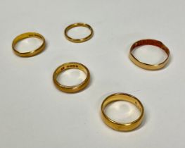 A 22ct gold wedding band, ring size K, marked 22ct, 5g; four other 22ct gold wedding bands, 12.4g