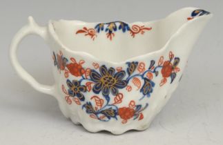 A Lowestoft Low Chelsea ewer, decorated in underglaze blue and overglaze red with flowers and