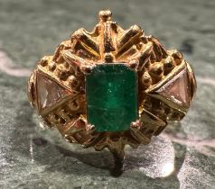 An emerald and diamond ring, rectangular emerald cut emerald approx 0.60ct, within ornate shield