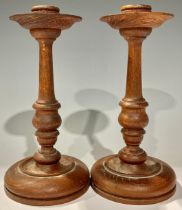 Treen - a pair of turned oak candlesticks, detachable drip pans, 22cm high, early 20th century