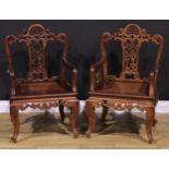 A pair of Chinese hardwood armchairs, each with a shaped back pierced and carved with scrolls and