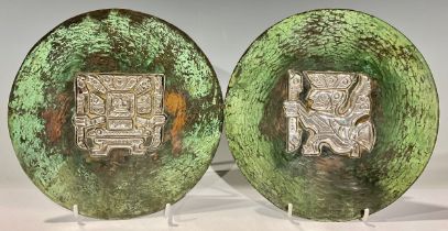 A pair of South American silver mounted copper dishes, decorated in the pre-Columbian taste, Peru,
